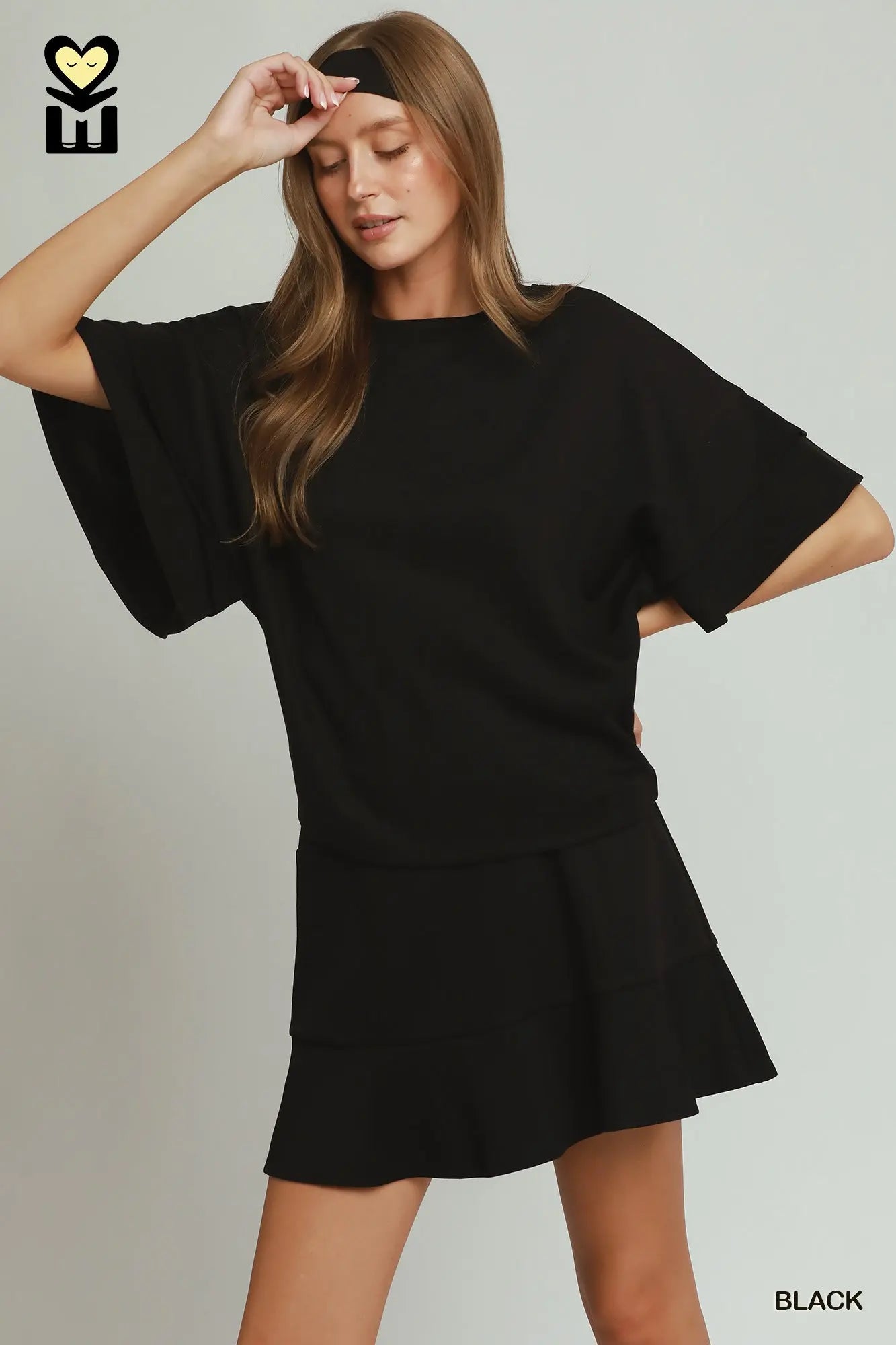 Woman wearing a black dress with a plain background