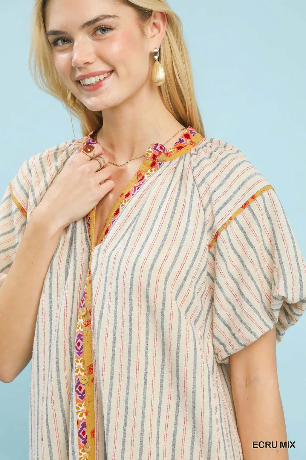Woman wearing a colorful striped shirt with a blue background
