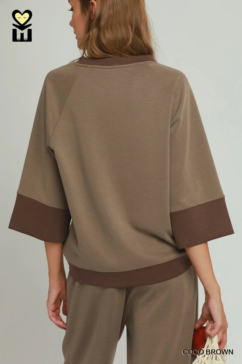 Person wearing a brown outfit with a plain background