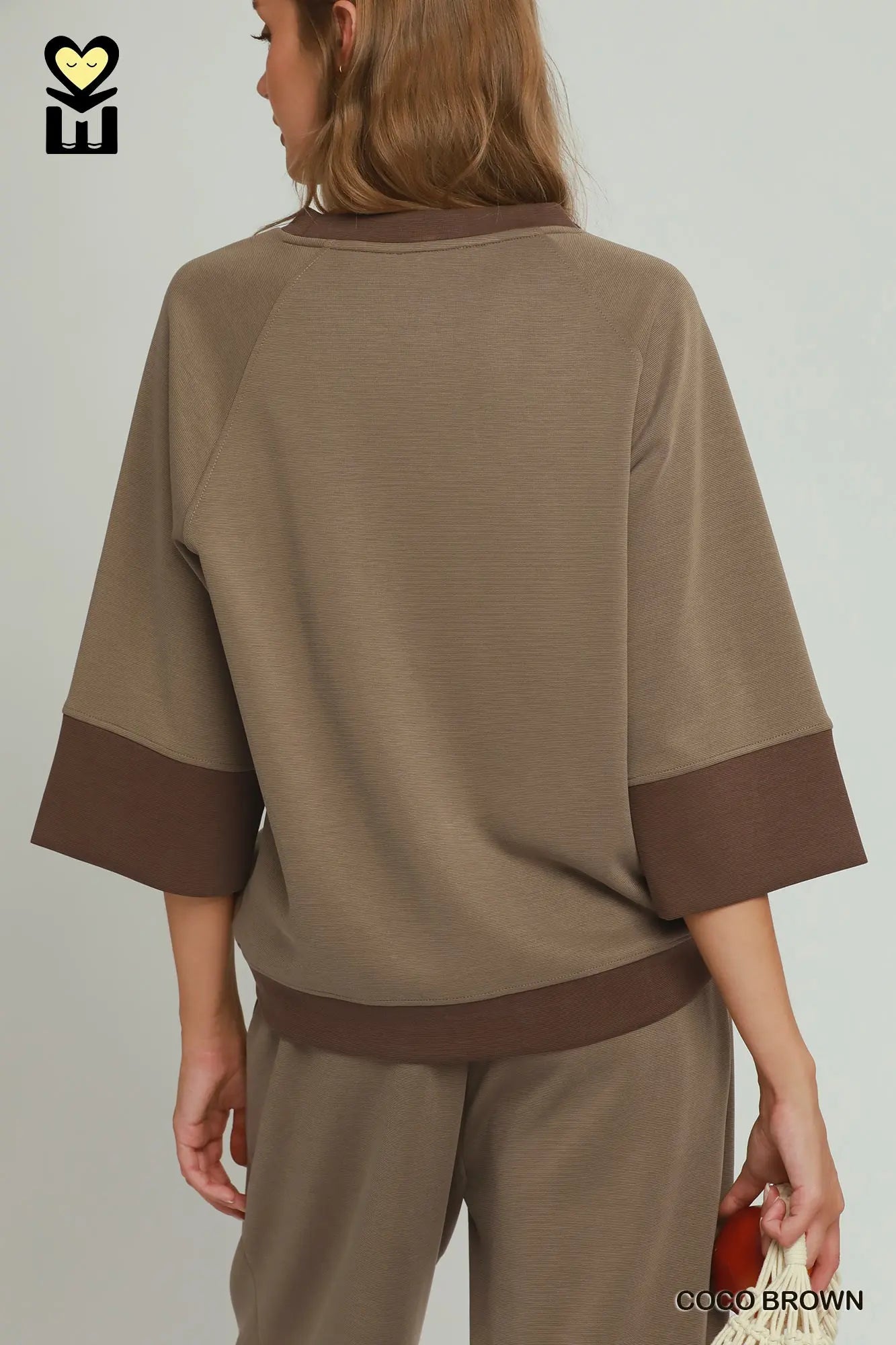 Person wearing a brown outfit with a plain background