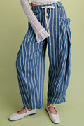 Blue and white striped pants worn by a person on a green background