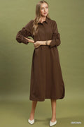 Woman wearing a brown dress against a green background