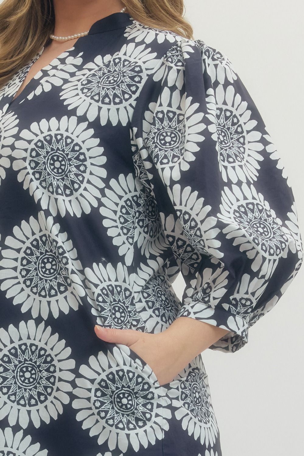 Navy blue dress with white floral pattern on a plain background