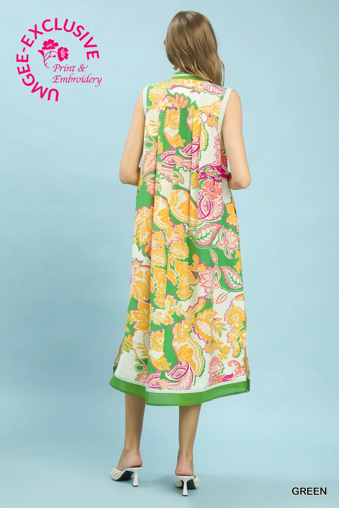 Woman wearing a colorful dress with floral pattern on a light blue background