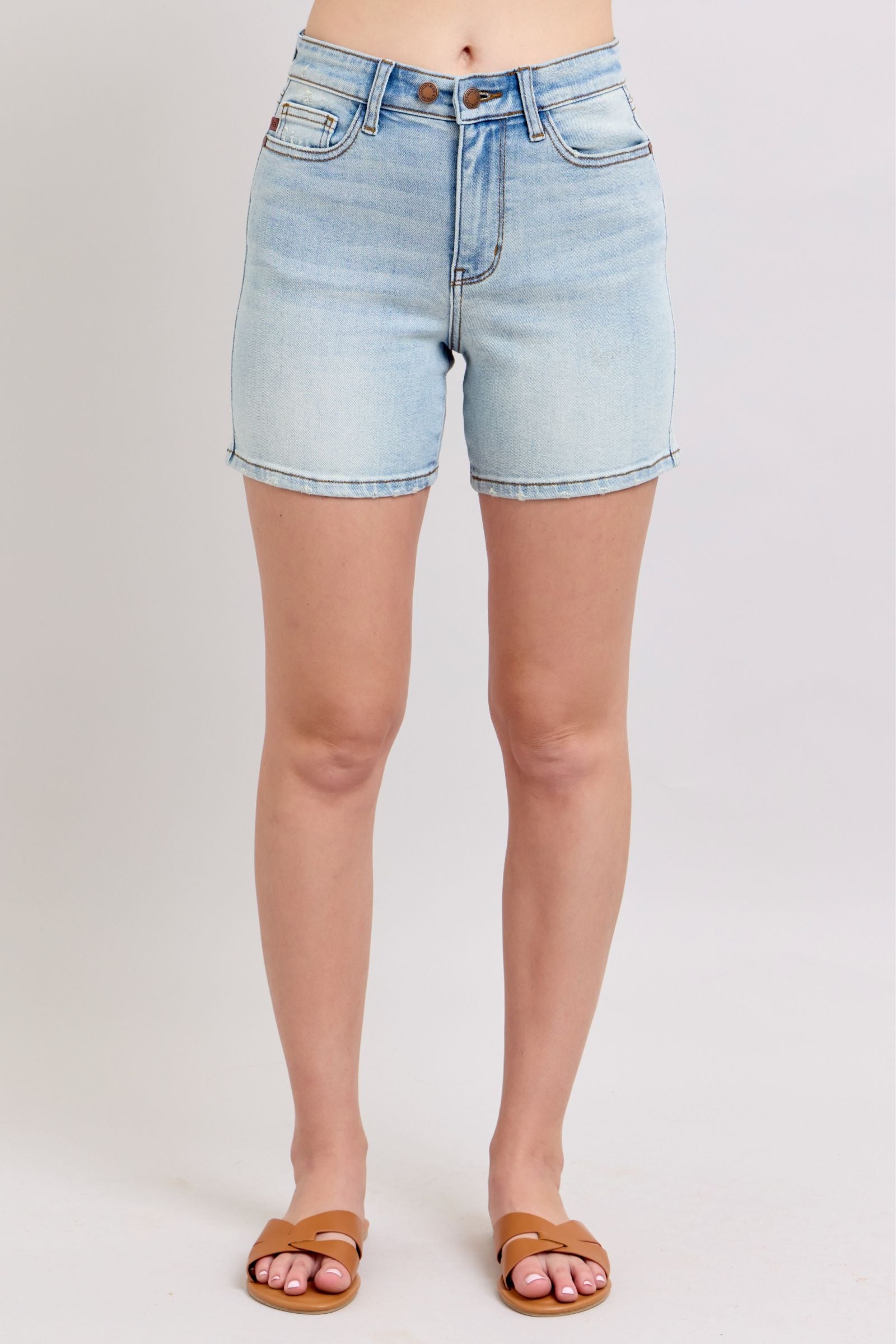 Light blue denim shorts worn by a person on a plain background