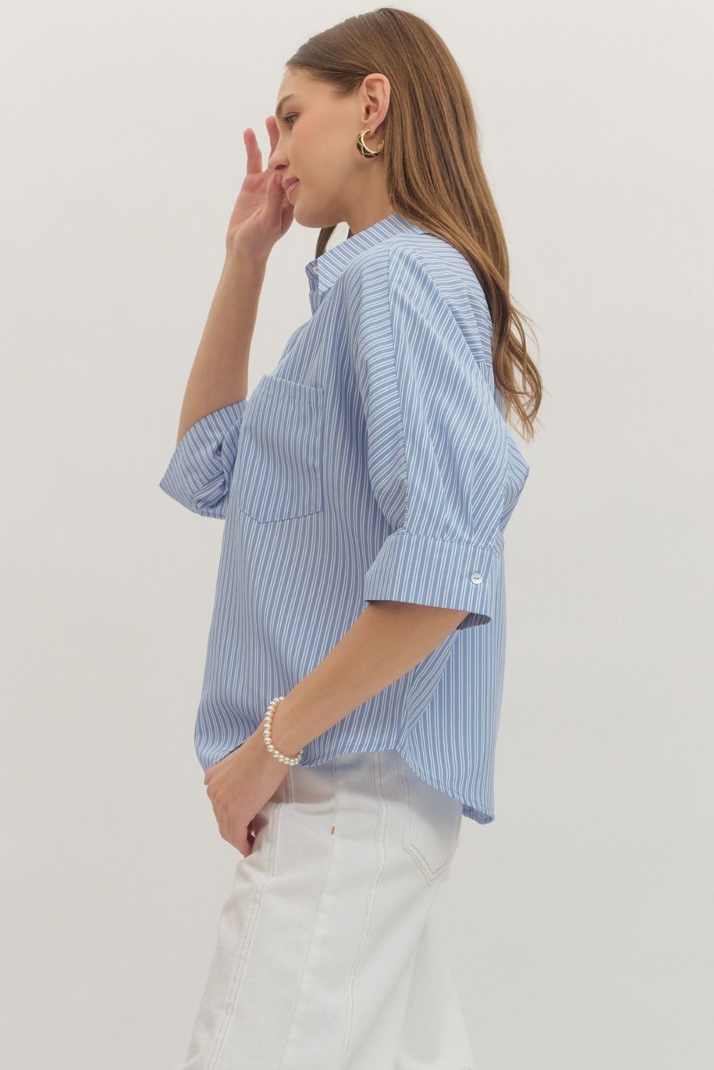 Woman wearing a blue and white striped shirt on a plain background