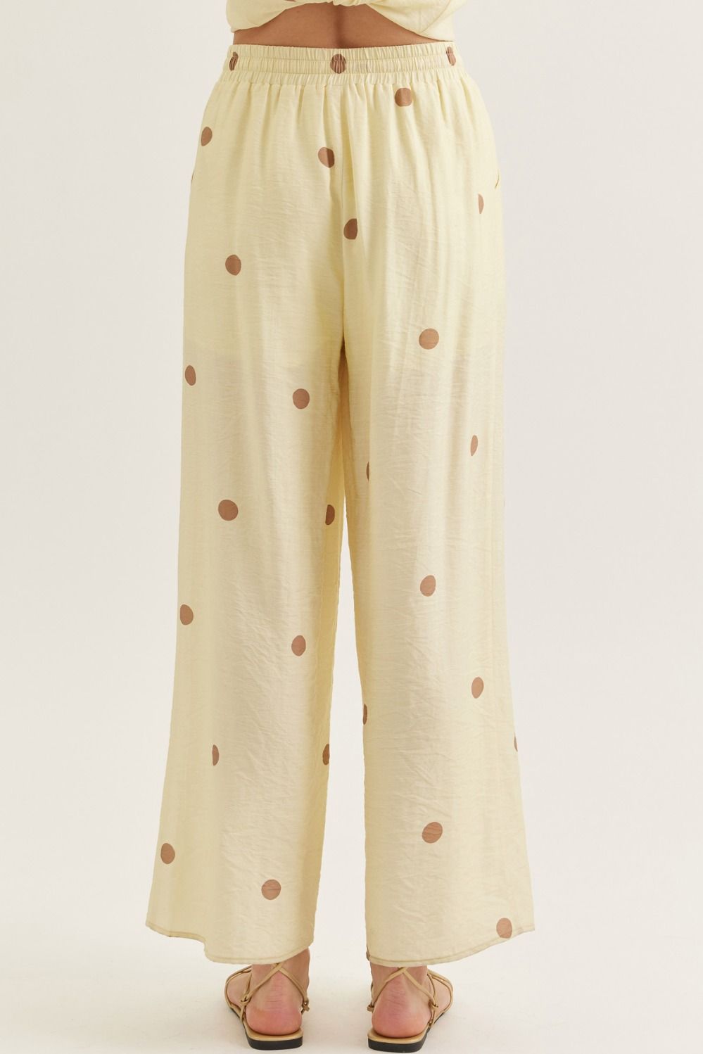 Light yellow pants with brown polka dots on a white background