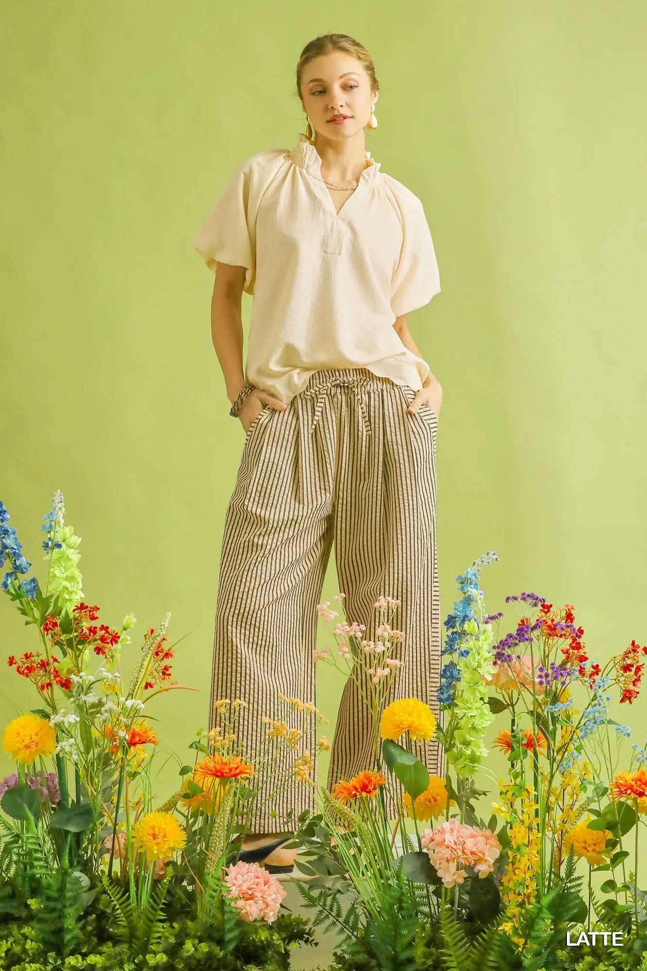 Woman standing among flowers with a green background