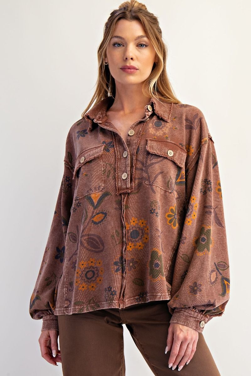 Woman wearing a brown floral patterned shirt on a white background