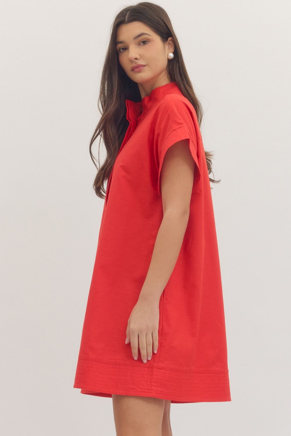 Woman wearing a red dress on a plain background