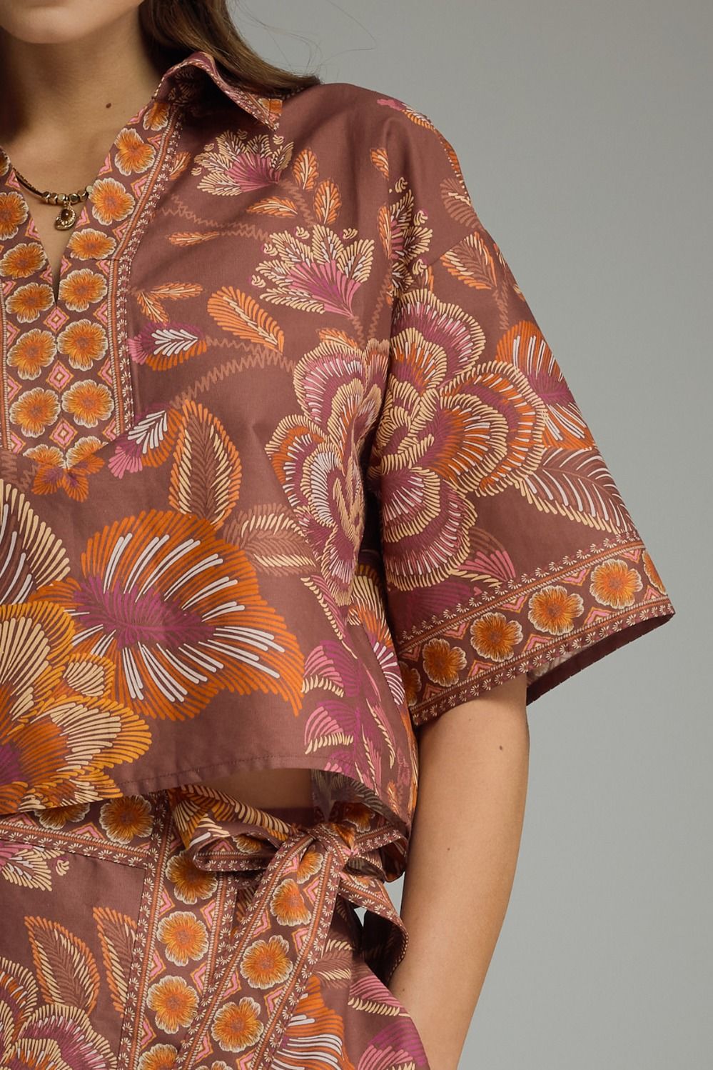 Brown floral patterned outfit on a plain background