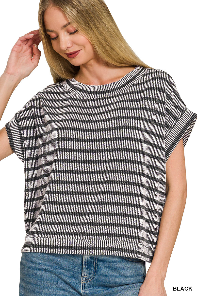 Woman wearing a black and white striped shirt with blue jeans on a white background