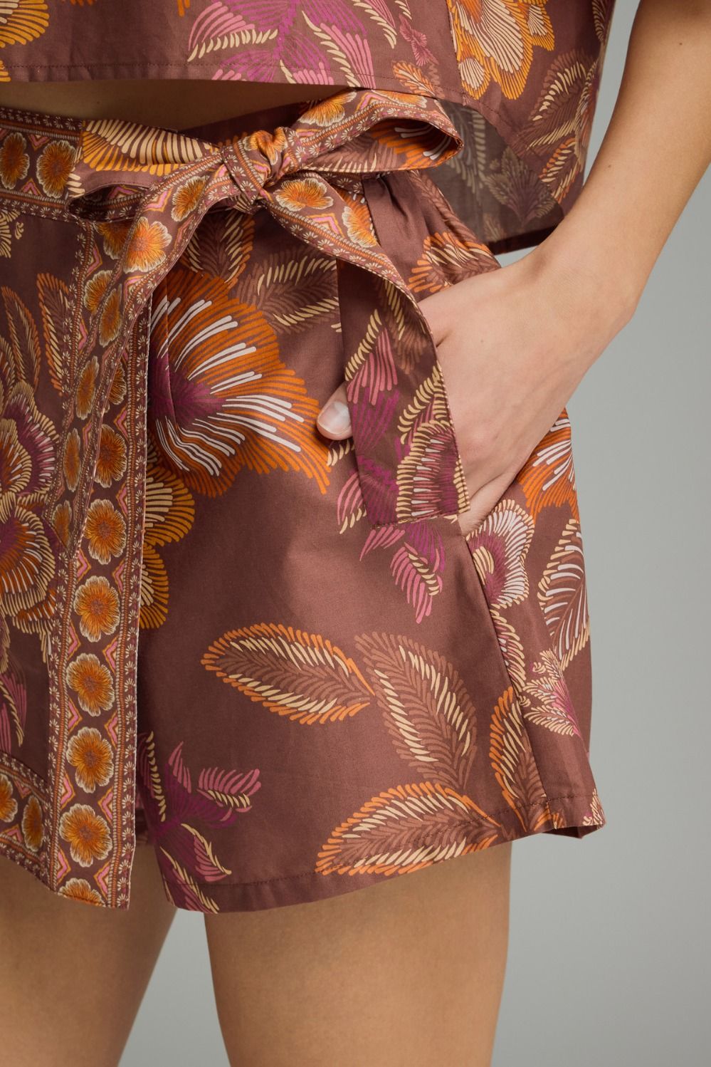 Close-up of a person wearing a patterned outfit with a brown and orange design.