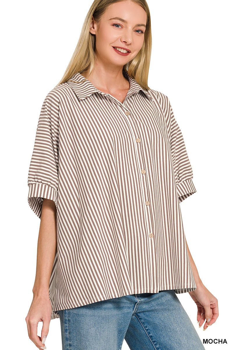 Woman wearing a brown and beige striped shirt with blue jeans on a white background