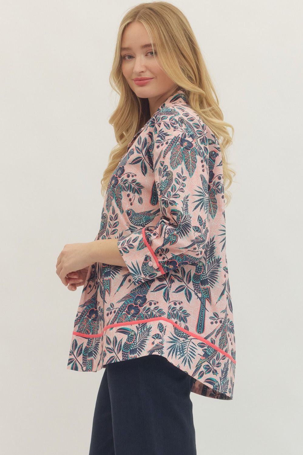 Woman wearing a floral kimono-style jacket with pink and green patterns on a white background
