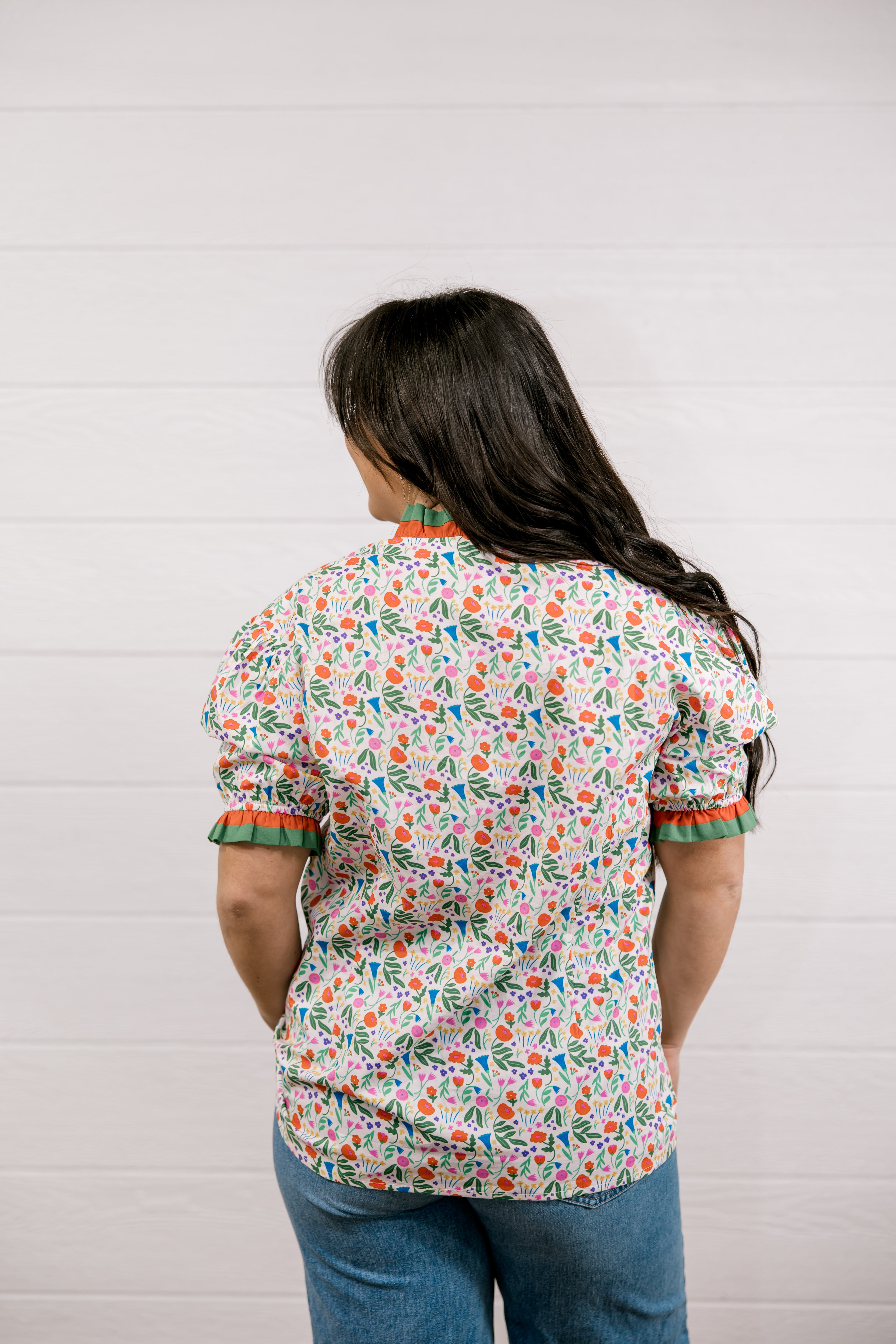 Person wearing a floral blouse with a white background