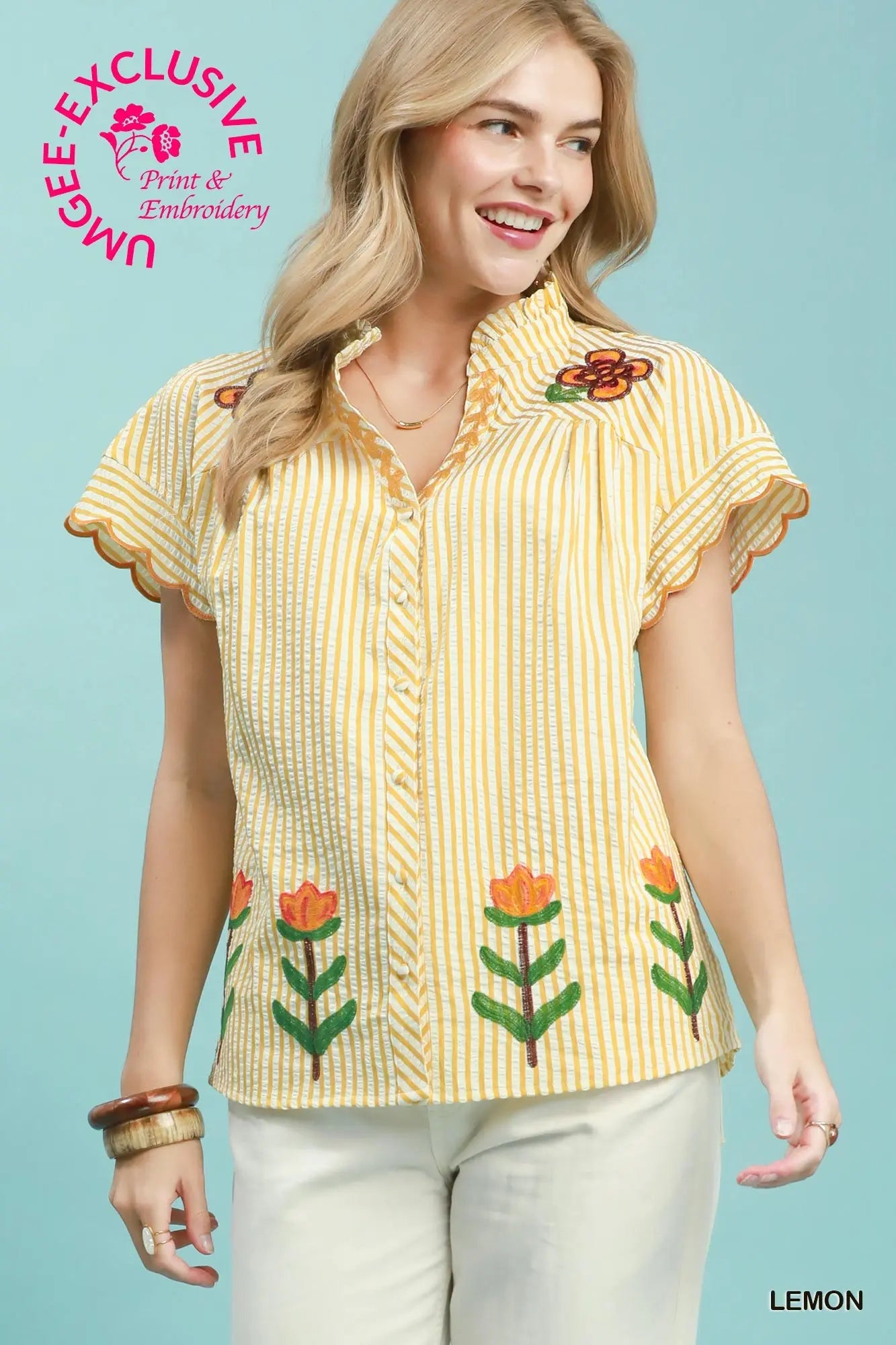Woman wearing a yellow blouse with floral embroidery on a light blue background