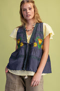 Woman wearing a floral embroidered vest on a green background