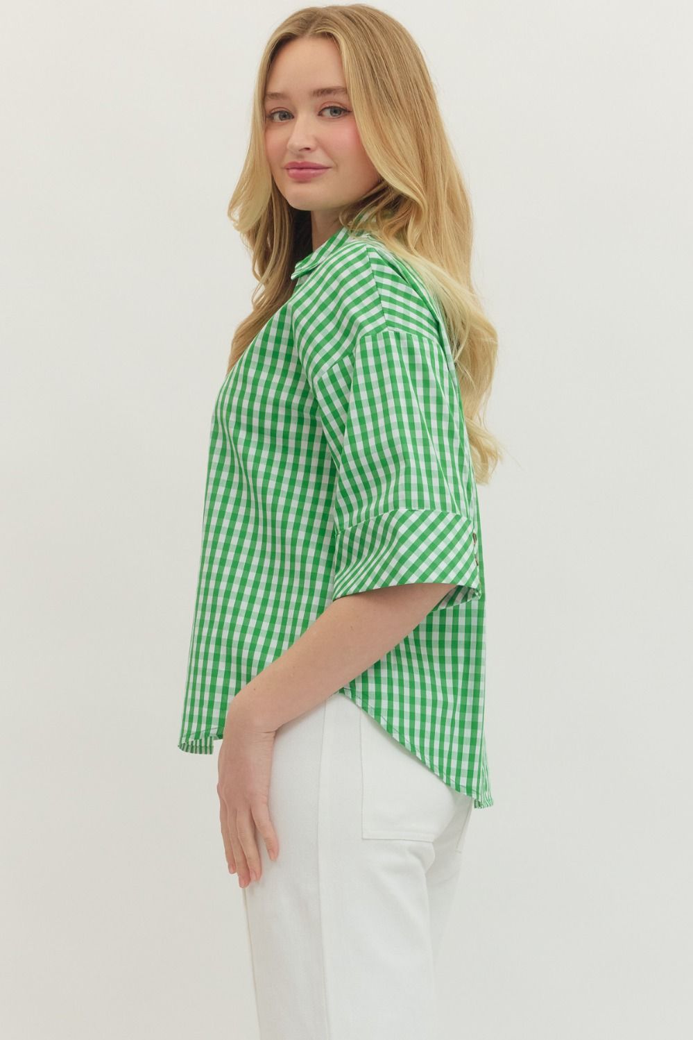 Woman wearing a green checkered shirt against a white background