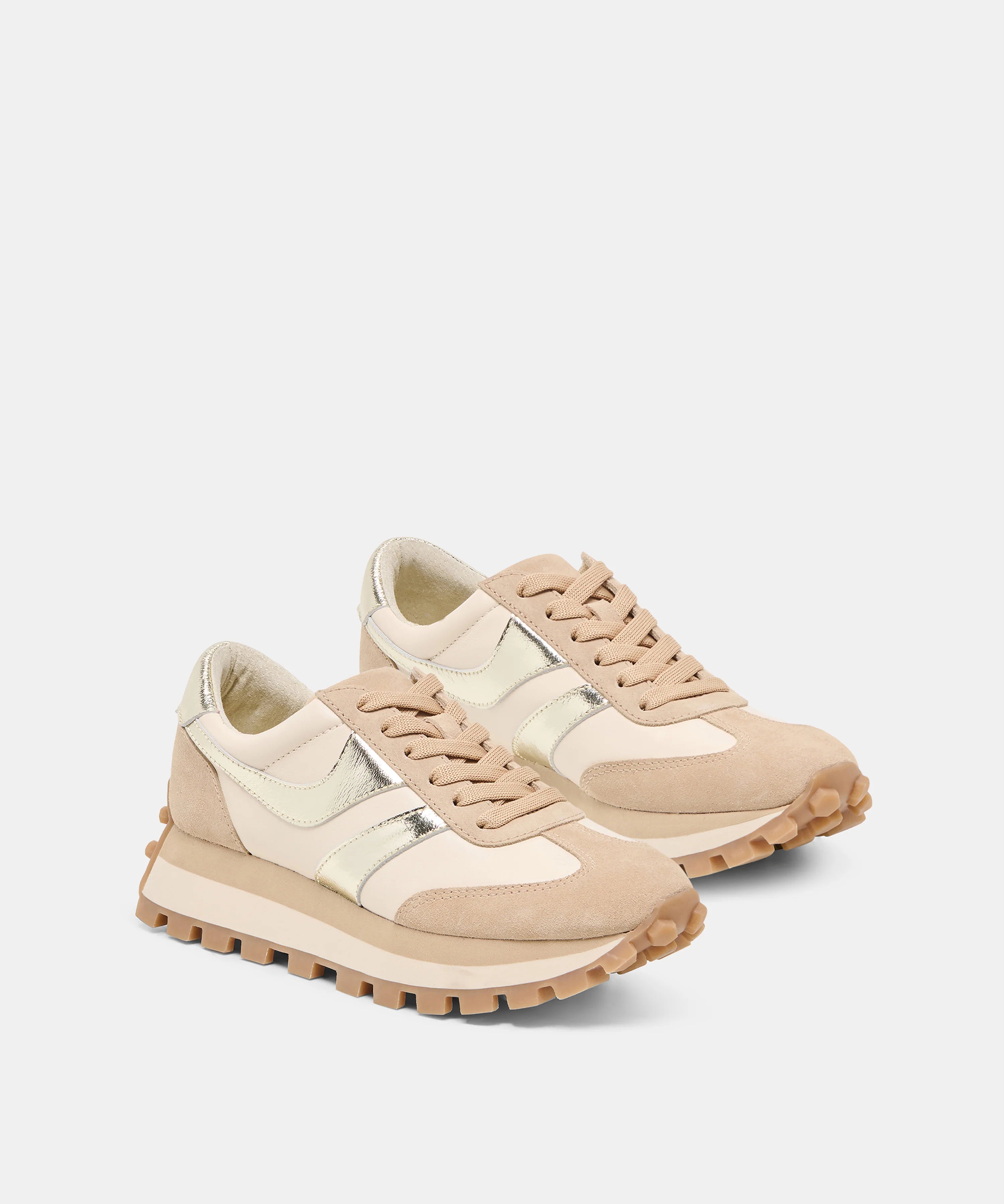 A pair of low-top sneakers in beige and cream suede and mesh, featuring metallic silver side stripes and chunky lug soles, set against a light gray background.