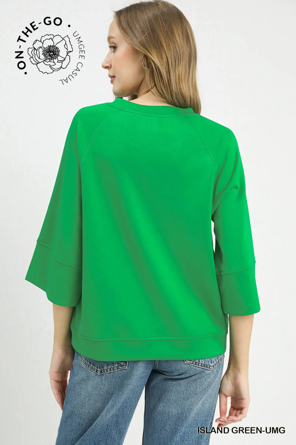 Woman wearing a green sweatshirt and blue jeans on a white background