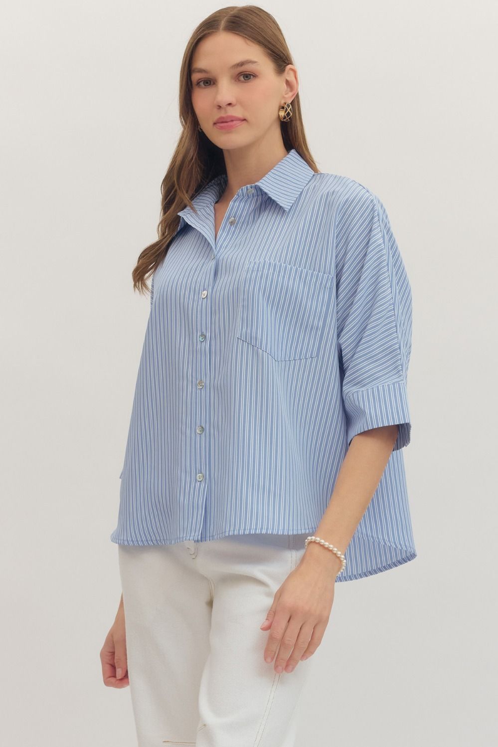 Woman wearing a blue striped shirt with a white background
