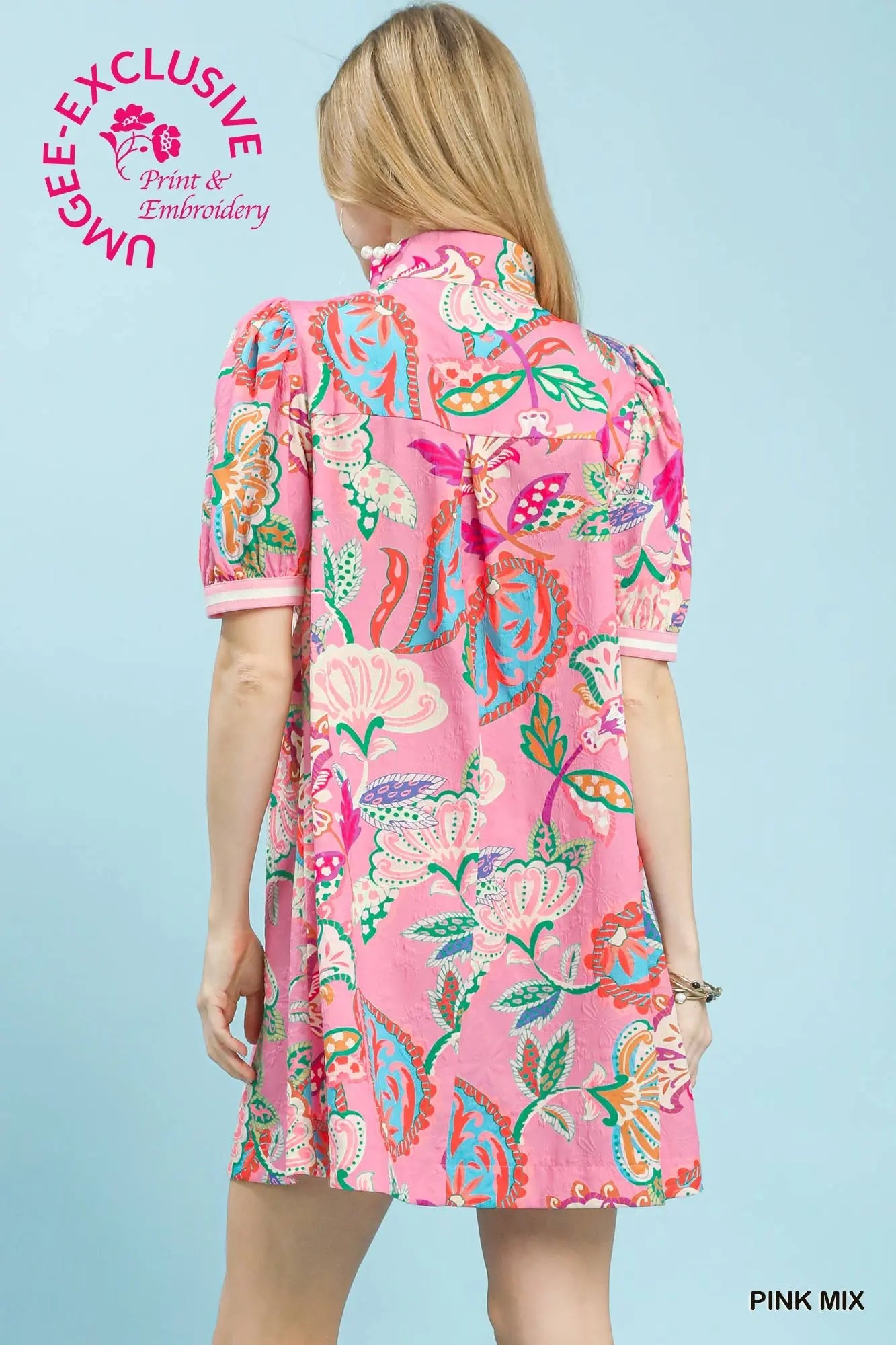 Woman wearing a pink floral dress with a blue background
