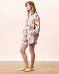 Woman wearing a colorful patchwork dress on a plain background