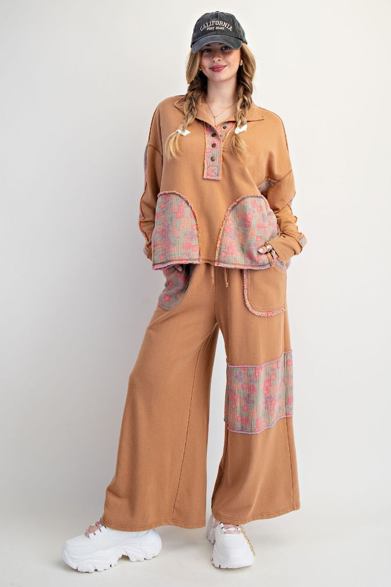Woman wearing a brown outfit with patterned patches on a white background