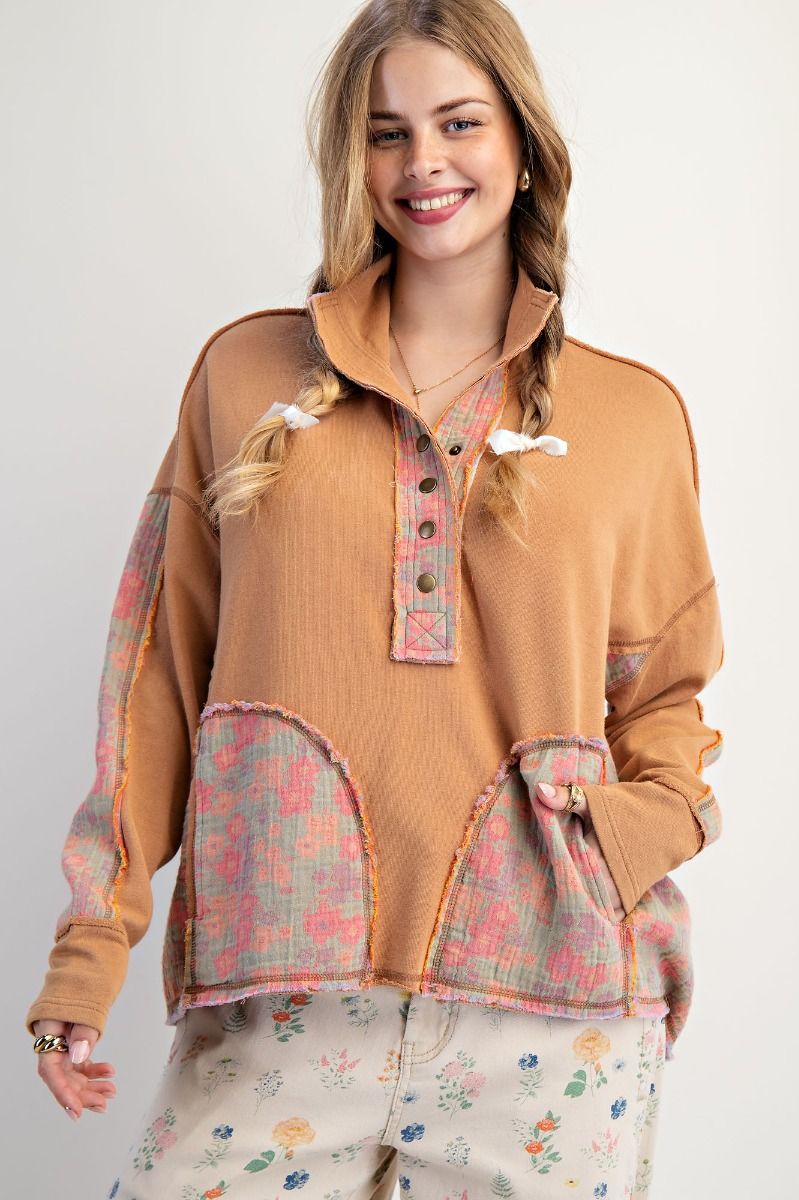 Woman wearing a brown jacket with floral patterns on a white background