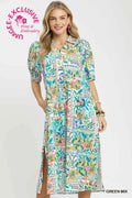Woman wearing a colorful floral dress with a visible brand logo on a white background
