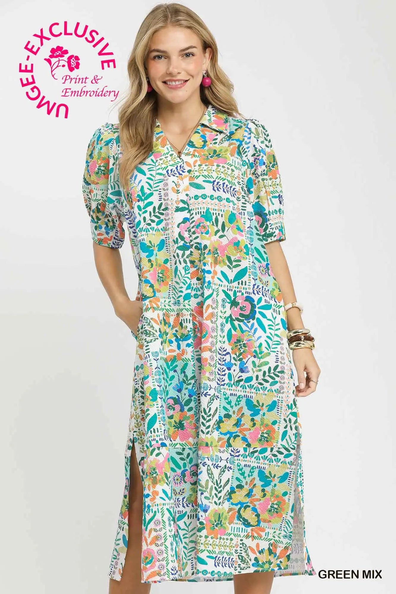 Woman wearing a colorful floral dress with a visible brand logo on a white background