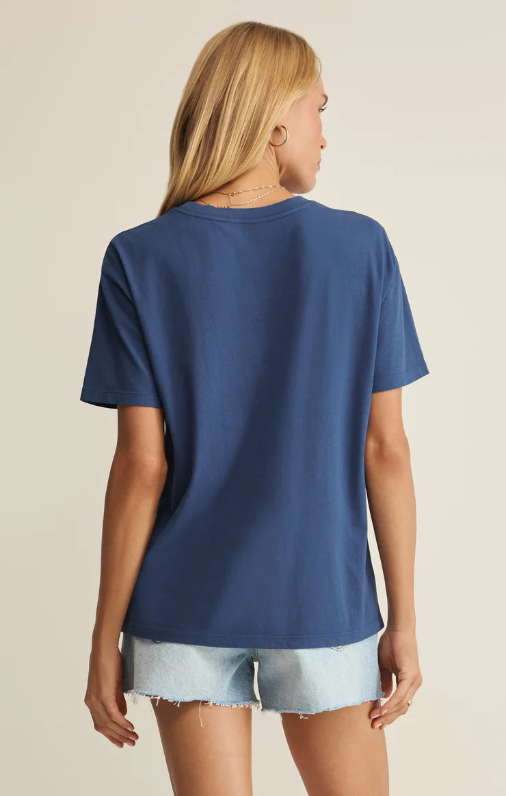 Person wearing a blue t-shirt and light denim shorts on a beige background