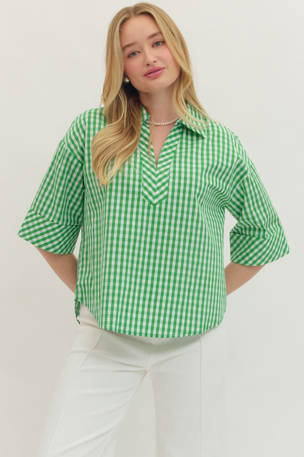 Woman wearing a green checkered shirt against a white background