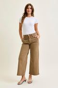 Woman wearing a white t-shirt and beige pants on a plain background