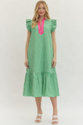 Woman wearing a green checkered dress with pink accents on a white background
