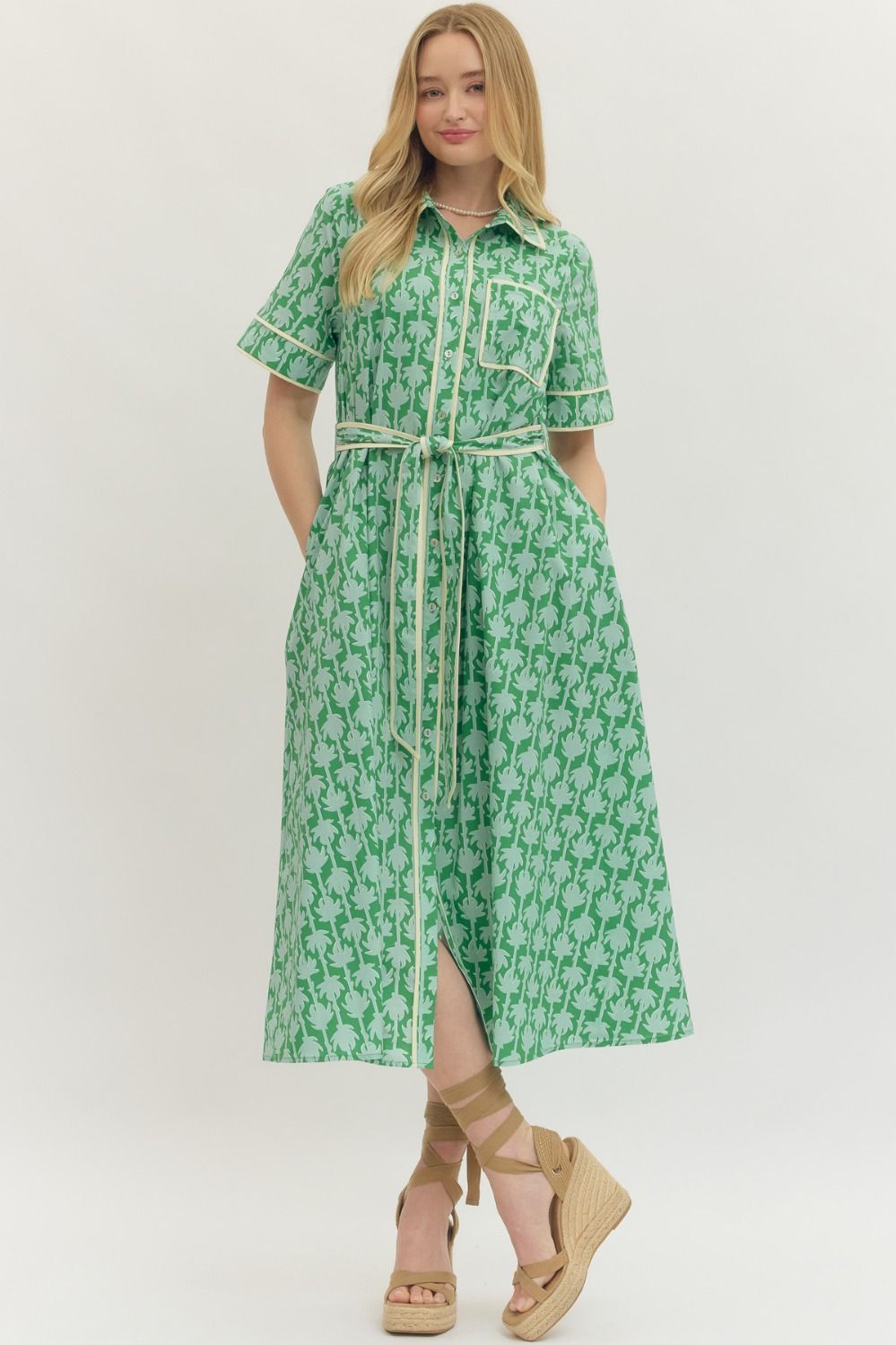 Woman wearing a green floral dress with a white background