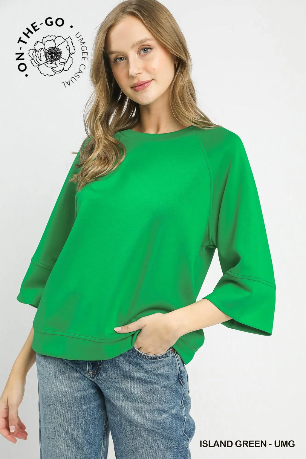 Woman wearing a green sweater with 'On-The-Go' branding on a white background