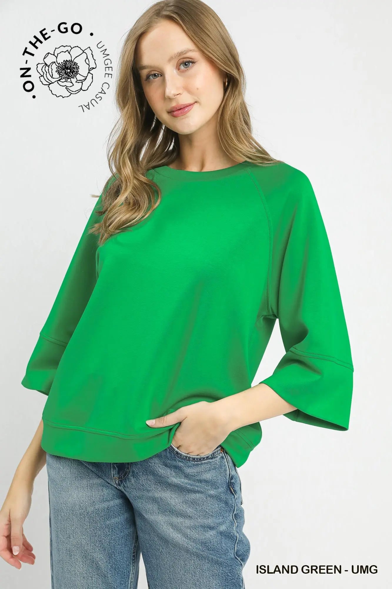 Woman wearing a green sweater with 'On-The-Go' branding on a white background