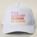 White cap with colorful text 'It's a good day to drink on a boat' on a beige background