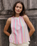 Woman wearing a colorful striped sleeveless top against a wooden background