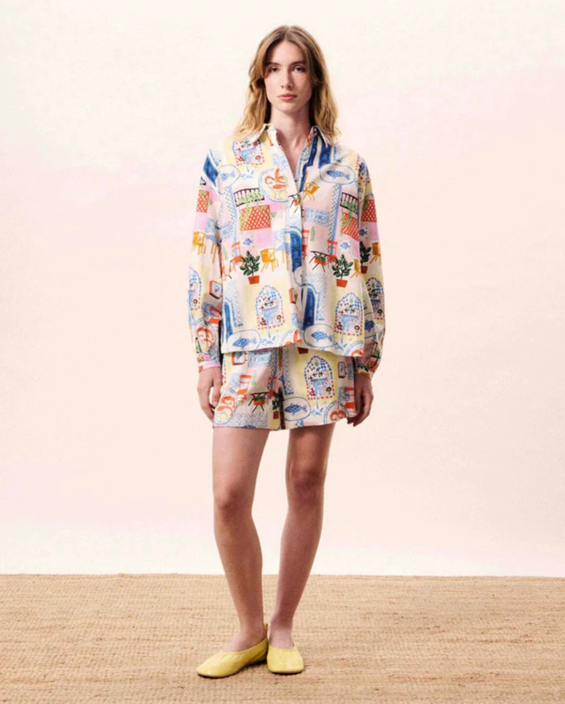 Woman wearing a colorful pajama set with a pattern on a beige background