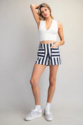Person wearing navy and white striped shorts on a plain background