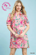 Woman wearing a pink floral dress with a light blue background