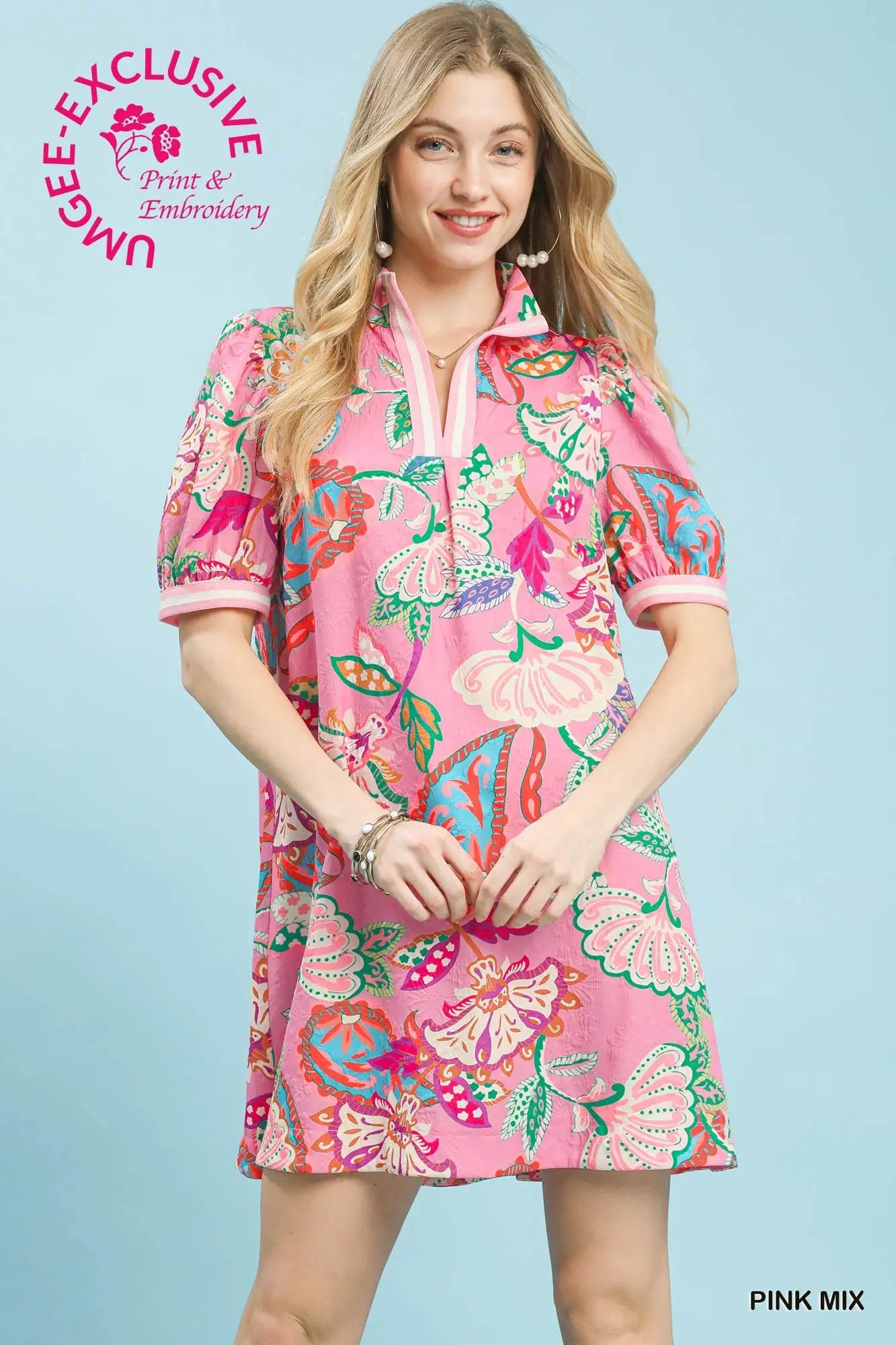 Woman wearing a pink floral dress with a light blue background