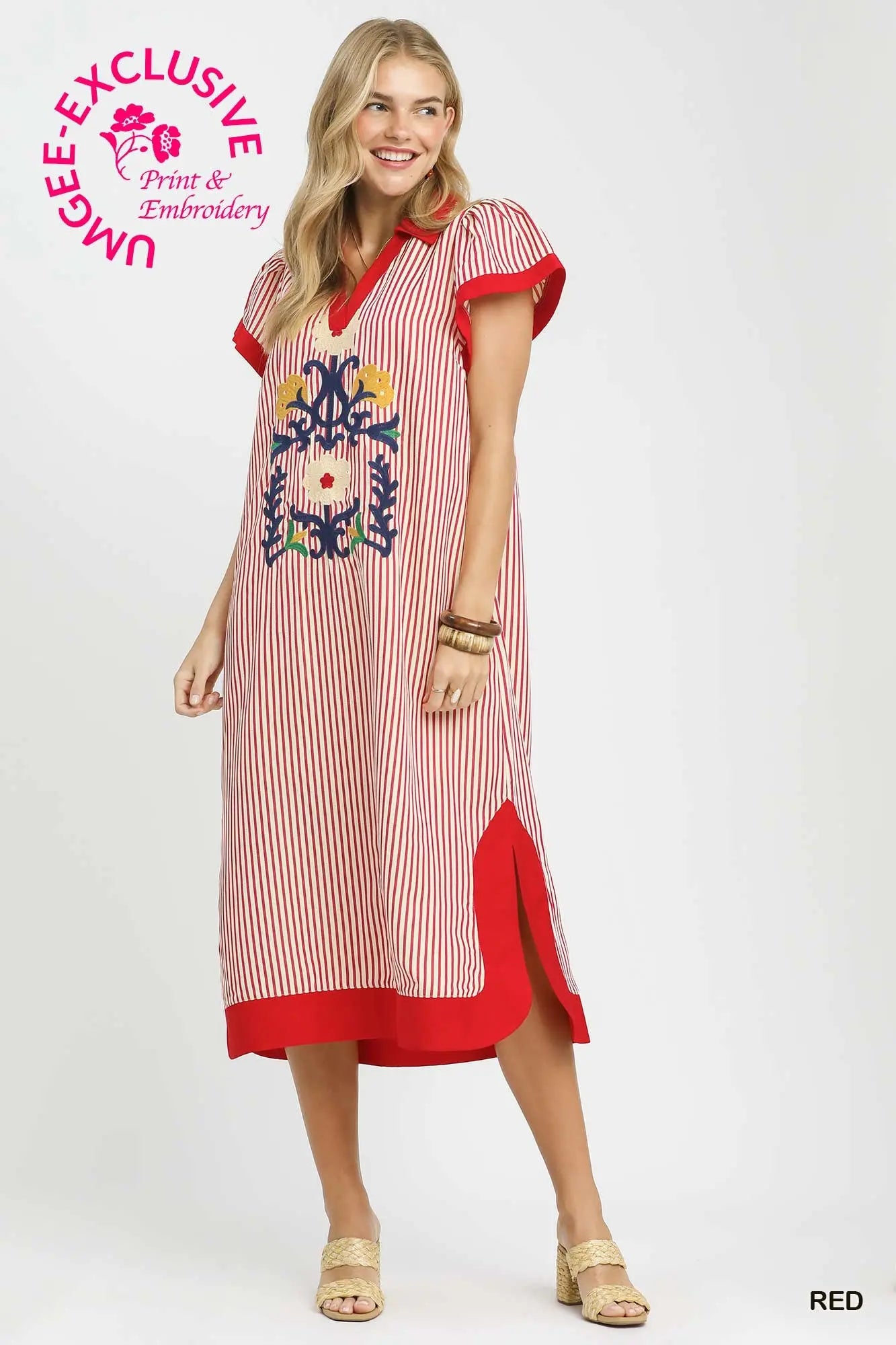 Woman wearing a red and white striped dress with floral embroidery on a white background