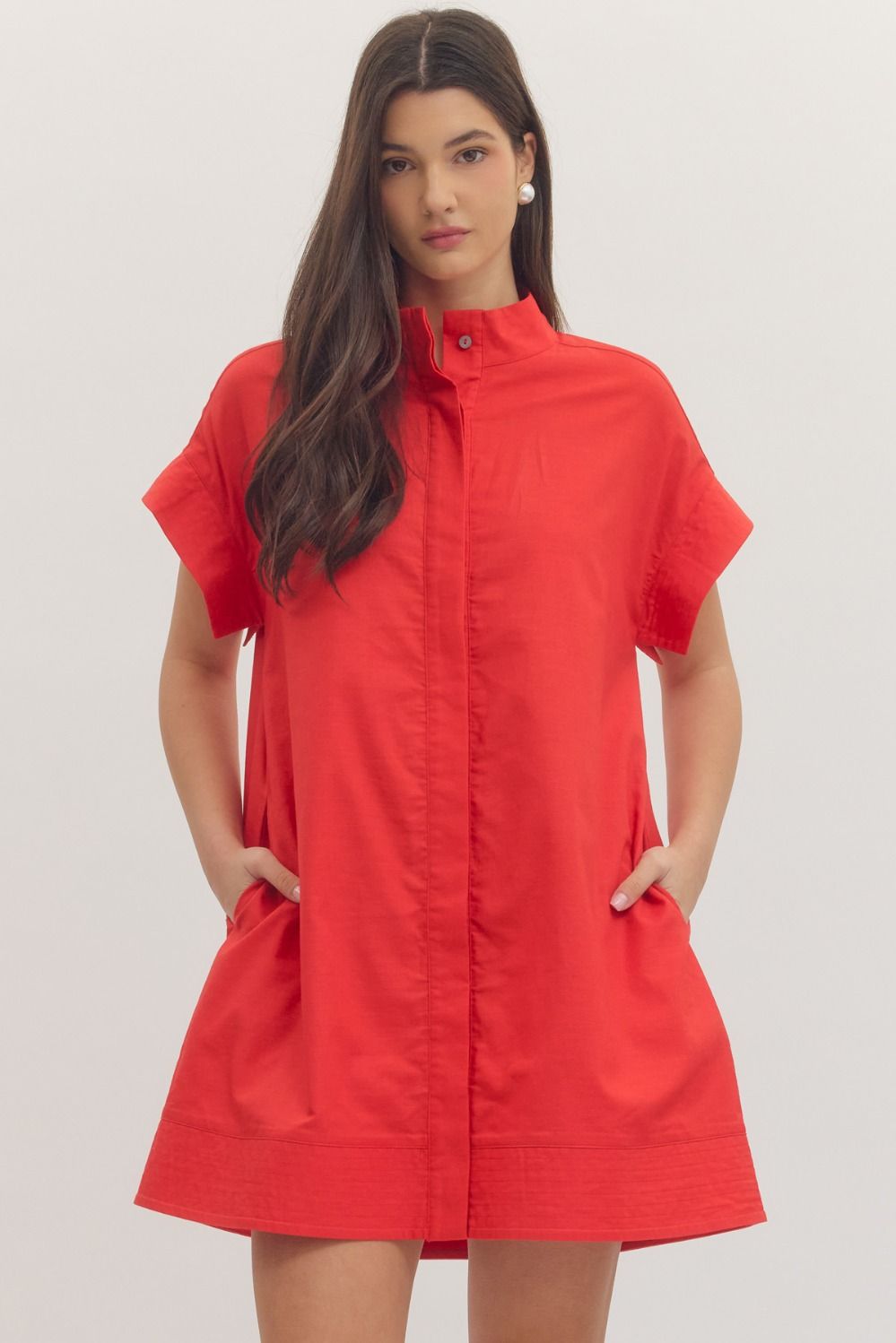 Woman wearing a red dress against a plain background