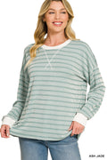 A woman wearing a light green and white striped long-sleeve knit top with white ribbed trim at the crew neck, cuffs, and hem, paired with blue jeans. The text 'ASH JADE' is visible in the bottom right corner.