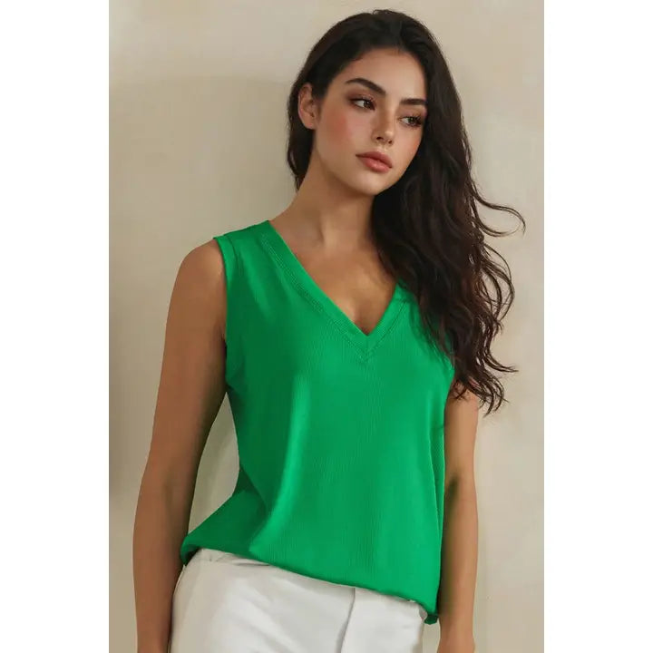 Woman wearing a green sleeveless top against a neutral background