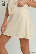 Beige skirt worn by a person on a plain background